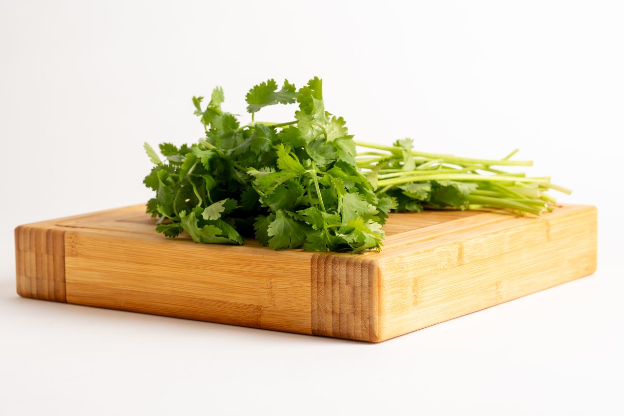 Product photography of cilantro on a wooden cutting board